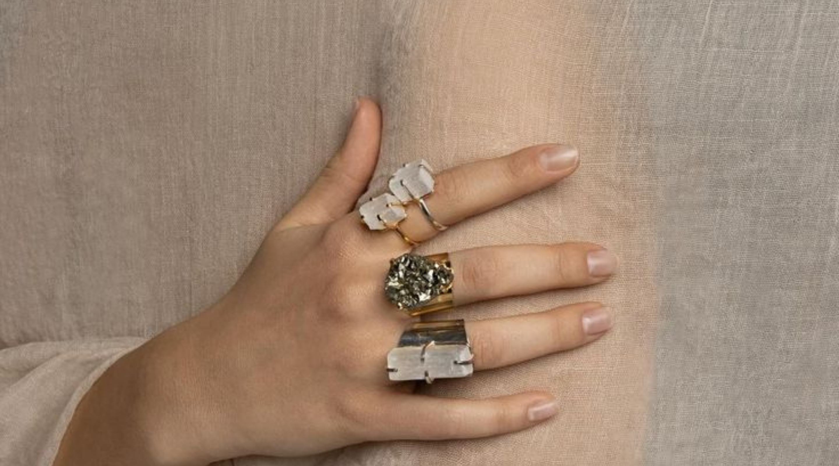 Manos con anillos de cuarzo sobre tela